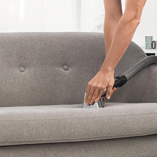Upholstery cleaning wand being used to remove dirt from couch